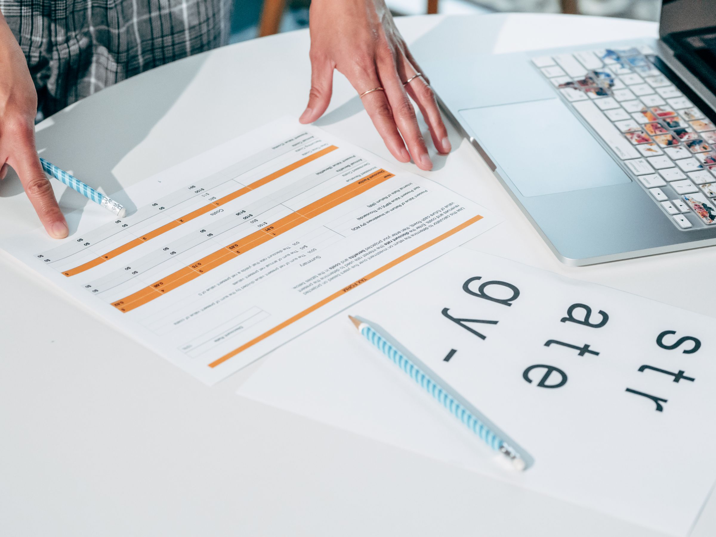 Professional reviewing documents beside a laptop